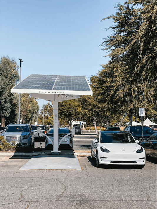 Tesla charging under solar panel canopy.